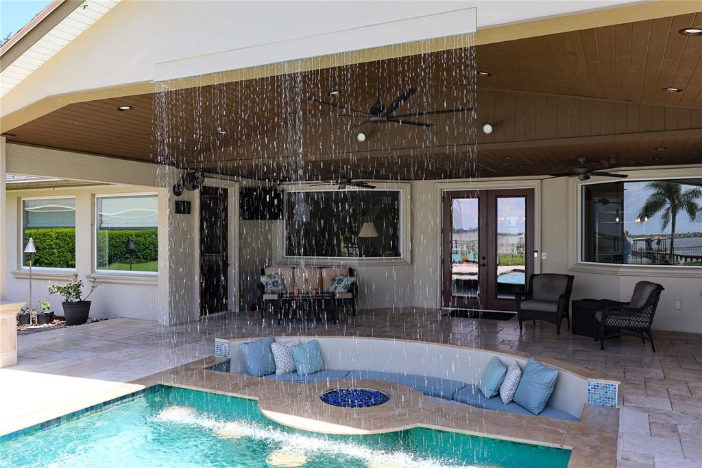 A covered patio features a sunken seating area with a fire pit beside a swimming pool — 3640 CRUMP ROAD, WINTER HAVEN, FL