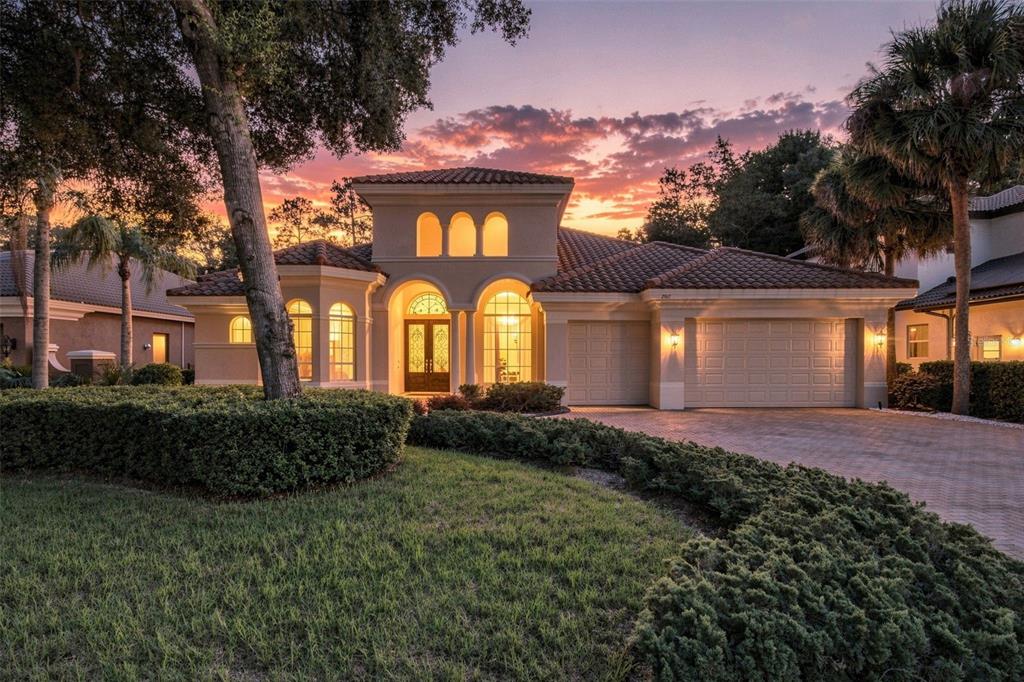 A single-story Mediterranean-style house with a tile roof, arched windows, and a three-car garage — 2967 GREY OAKS BOULEVARD, TARPON SPRINGS, FL