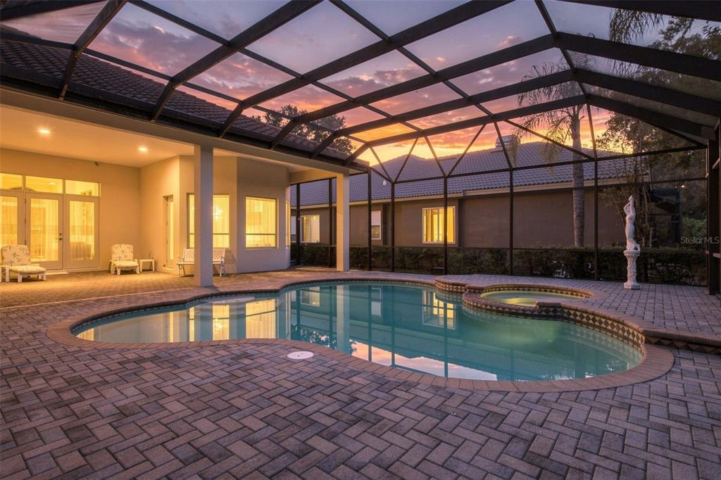 A single-story stucco house with a tile roof and a paved driveway at sunset — 2967 GREY OAKS BOULEVARD, TARPON SPRINGS, FL