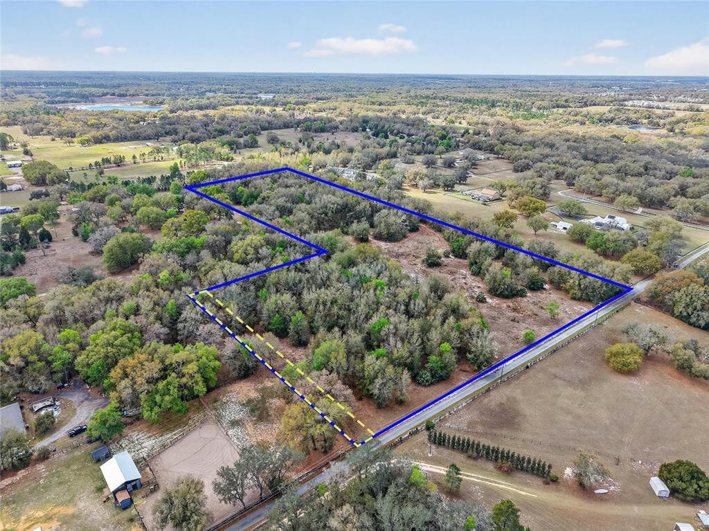 An aerial view shows a wooded plot of land outlined in blue and yellow — 3800 DOUBLE D CIRCLE R, LADY LAKE, FL