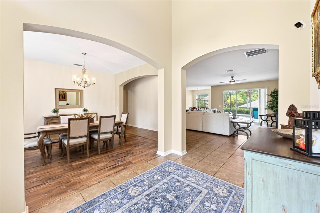 An entryway with a blue rug leads to a dining room and a living room — 2651 CEDAR CREST DRIVE, APOPKA, FL