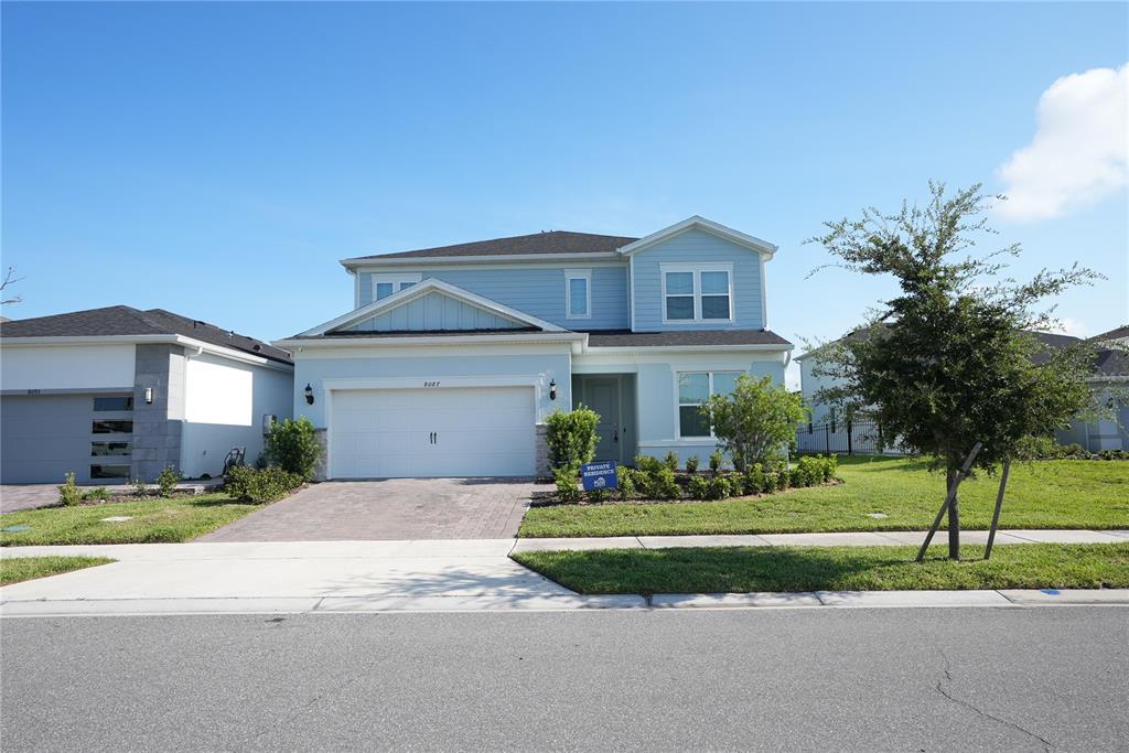 A two-story light blue house with a two-car garage and a paved driveway — 8087 FENTON STREET, ORLANDO, FL