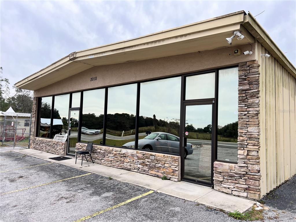 A single-story commercial building features a stone facade, large reflective windows, and two glass doors — 2018 N FLORIDA AVENUE, HERNANDO, FL