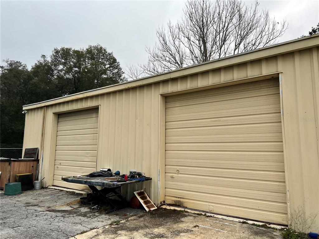 The exterior of a metal building features two large roll-up garage doors — 2018 N FLORIDA AVENUE, HERNANDO, FL