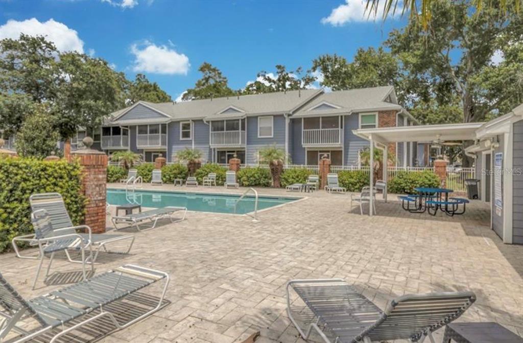 An aerial view shows a community swimming pool surrounded by a patio and apartment buildings — 5457 LAKE MARGARET DRIVE UNIT 19-1, ORLANDO, FL