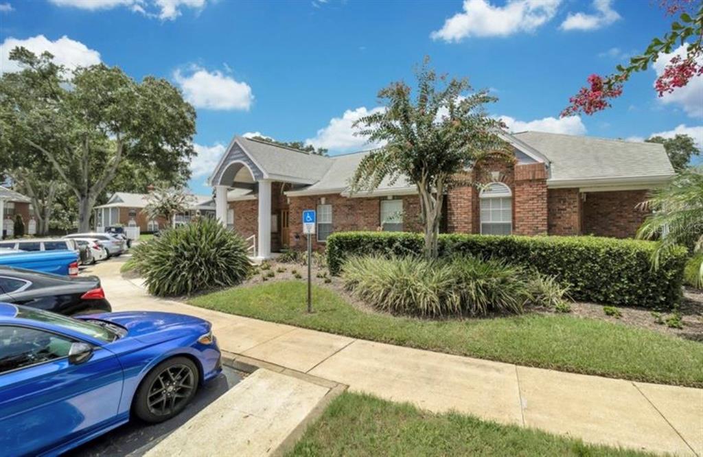 A swimming pool with lounge chairs and a covered patio area in a residential complex — 5457 LAKE MARGARET DRIVE UNIT 19-1, ORLANDO, FL