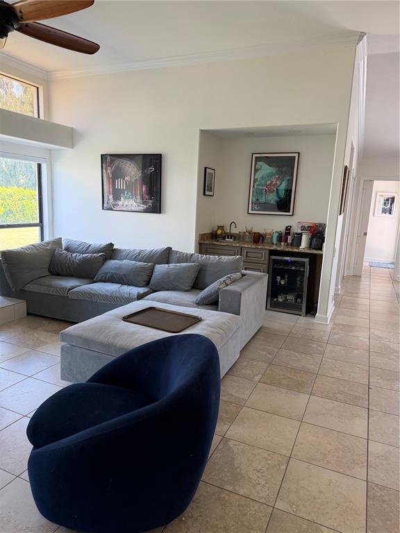 A living room features a large gray sectional sofa, a dark blue chair, and a wet bar — 4931 FALLCREST CIRCLE, SARASOTA, FL
