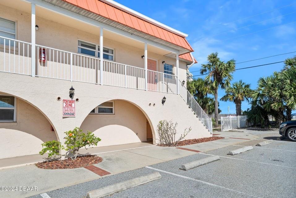 An exterior view of a two-story building with a staircase and a parking lot — 1510 OCEAN SHORE BOULEVARD UNIT 3150, ORMOND BEACH, FL