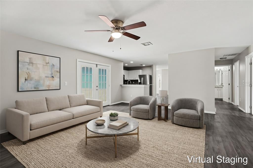 An entryway with gray wood-look flooring, a white front door, and a dining nook area — 449 DANUBE DRIVE, KISSIMMEE, FL