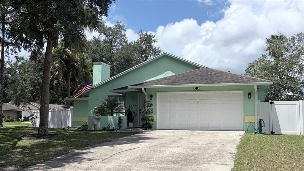 A light green single-story house with a two-car garage and a paved driveway — 4142 YELLOWWOOD DRIVE, VALRICO, FL