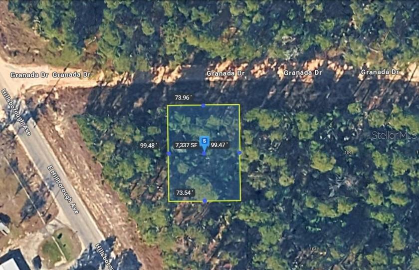 An aerial view shows a rectangular plot of land outlined in yellow near a road — 105 GRANADA DRIVE, FLORAHOME, FL