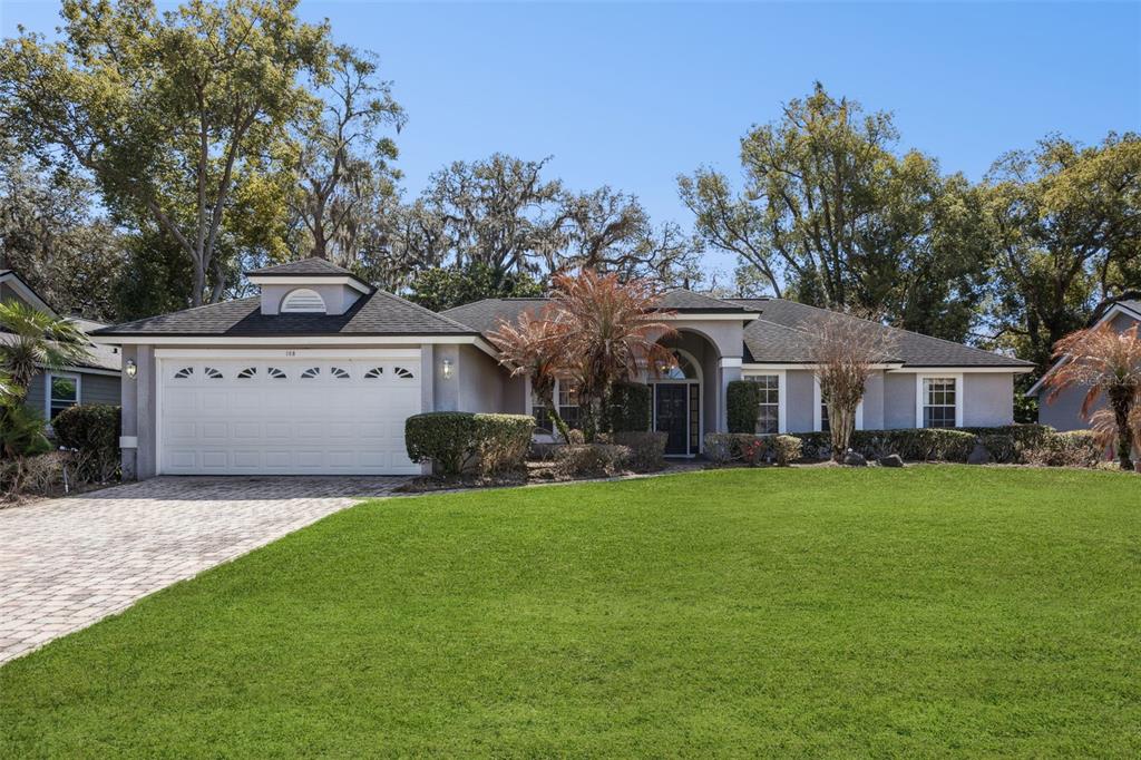 A single-story house with a white garage, gray stucco exterior, and a paved driveway — 108 OAK VIEW CIRCLE, LAKE MARY, FL