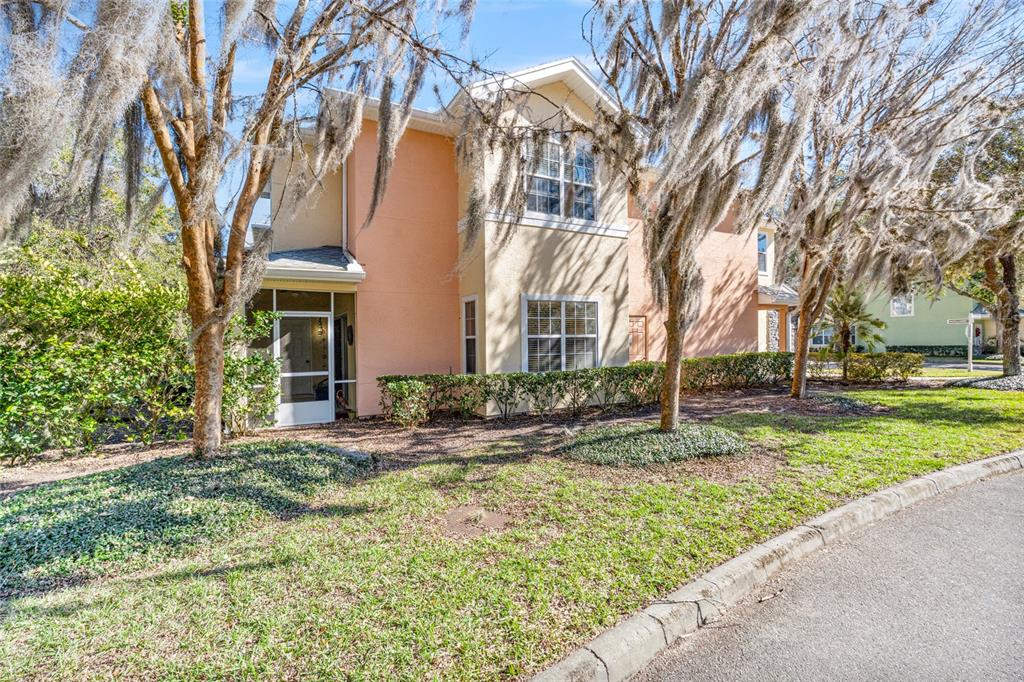 A two-story townhouse with a tan stucco exterior, stone accents, and a two-car garage — 110 MAGNOLIA CROSSING POINT UNIT 1901, ST AUGUSTINE, FL