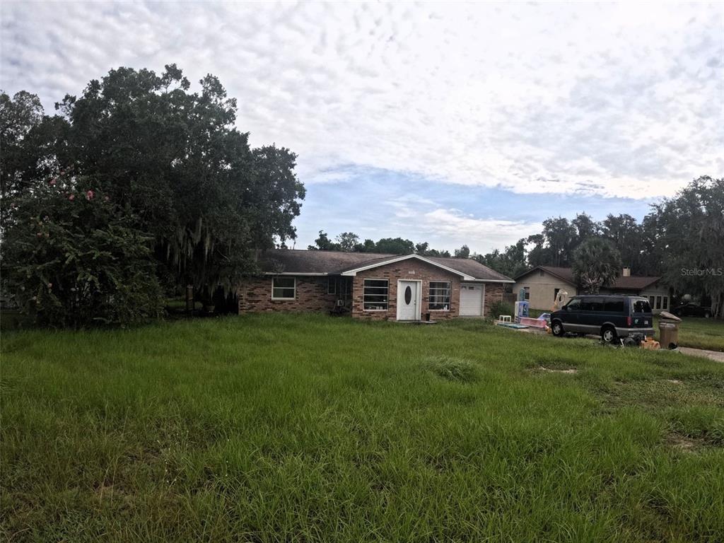 A single-story brick house with a front lawn and an attached garage — 5243 EAGLES NEST ROAD, FRUITLAND PARK, FL