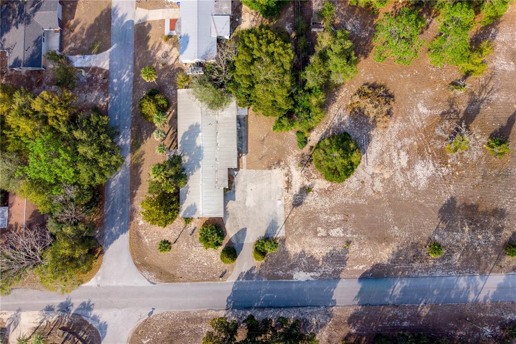 A single-story house with a flat roof sits behind a lawn and paved driveway — 15851 NE 15TH STREET, WILLISTON, FL