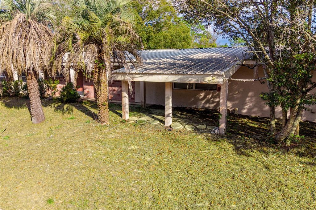 A single-story house with a covered porch sits behind a large lawn and paved driveway — 15851 NE 15TH STREET, WILLISTON, FL