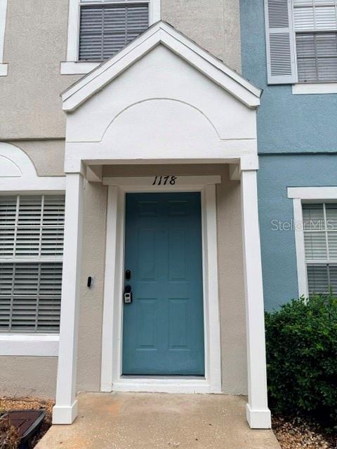 The exterior of a residential building features a blue front door under a gabled porch — 1178 VINELAND PLACE, LAKE MARY, FL
