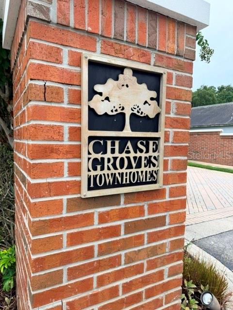 A brick pillar displays a sign for Chase Groves Townhomes featuring a tree icon — 1178 VINELAND PLACE, LAKE MARY, FL