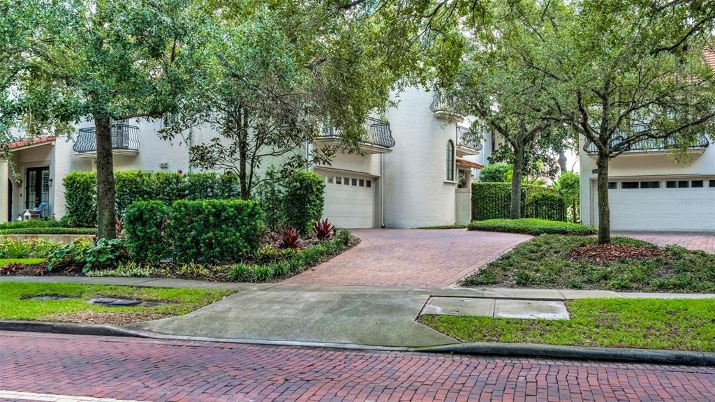 A brick driveway leads to the garages of two white multi-story homes with balconies — 1256 S PENNSYLVANIA AVENUE UNIT 9, WINTER PARK, FL