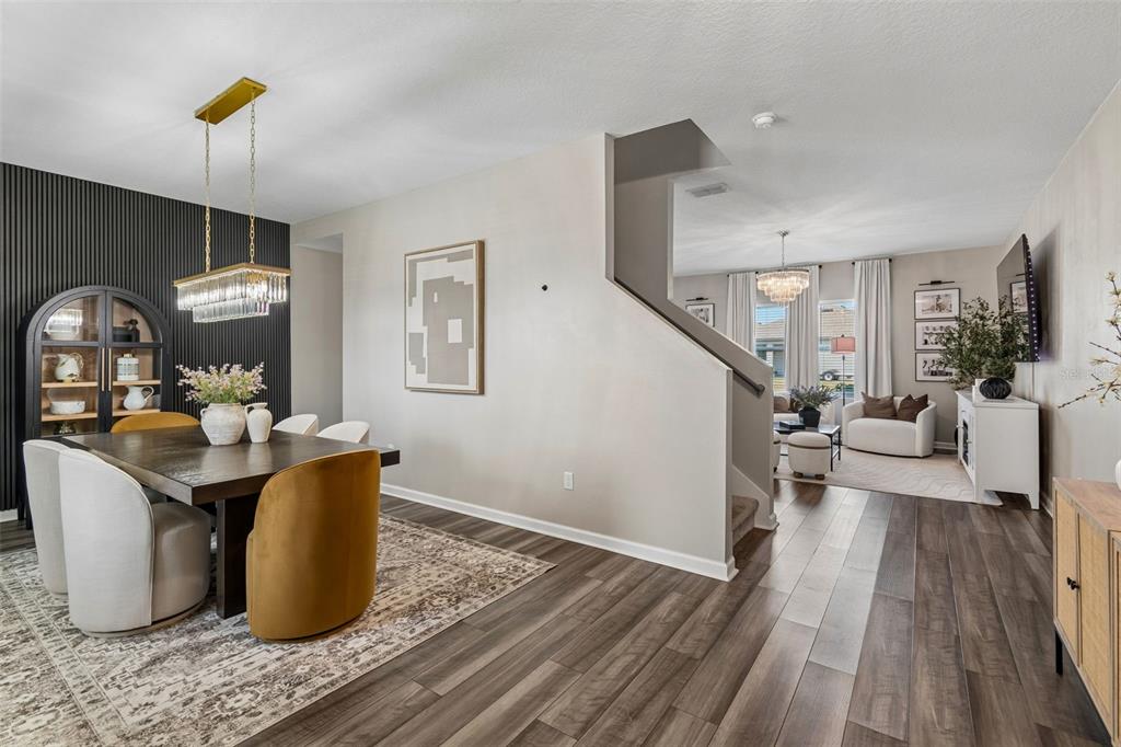 A dining area with a dark accent wall and a staircase leading to a living room — 575 OCEAN SPRAY DRIVE, RUSKIN, FL