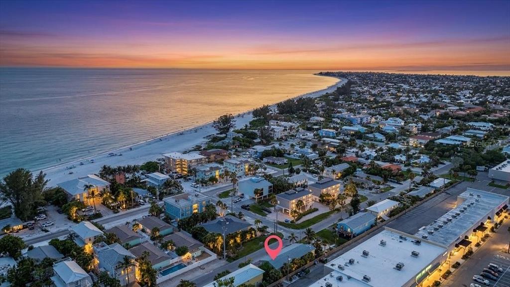 An aerial view shows a coastal neighborhood at sunset with a red location pin marker — 3303 6TH AVENUE UNIT B, HOLMES BEACH, FL