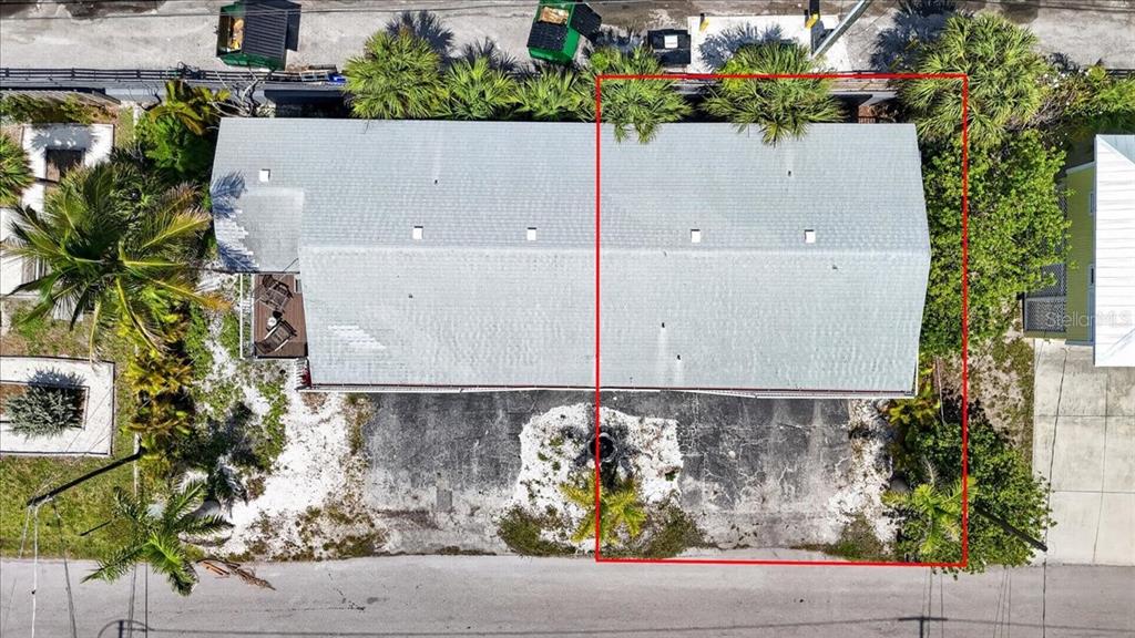 An aerial view shows a rectangular building with a gray roof and a paved lot — 3303 6TH AVENUE UNIT B, HOLMES BEACH, FL