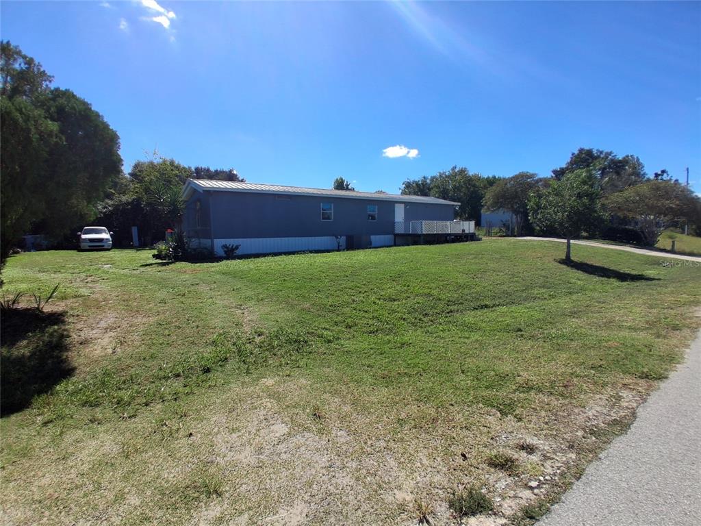 A gray mobile home sits on a grassy lot under a clear blue sky — 6290 SE 140TH PLACE, SUMMERFIELD, FL