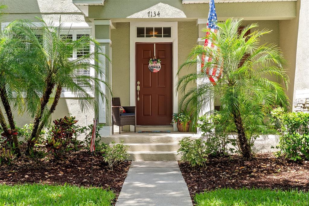 A front entrance features a brown door, two palm trees, and an American flag — 7134 FIVE OAKS DR UNIT 4B, ST CLOUD, FL