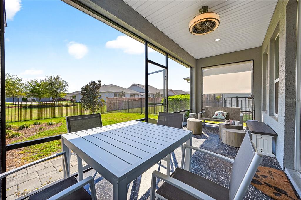 A screened-in patio with a dining set, seating area, and a view of a backyard — 5608 NW 39TH LANE, OCALA, FL