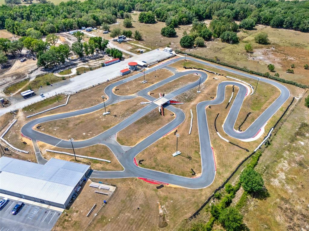 An aerial view shows an outdoor go-kart track with a large building and parking lot — 5821 PIT ROAD, BUSHNELL, FL