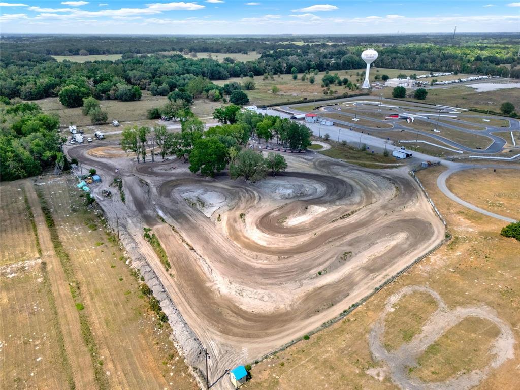 An aerial view shows a dirt motocross track adjacent to a paved go-kart circuit — 5821 PIT ROAD, BUSHNELL, FL