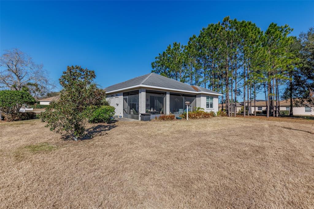 A single-story house with a screened-in lanai sits on a large, dry grassy lot — 2291 N MIA POINT, LECANTO, FL