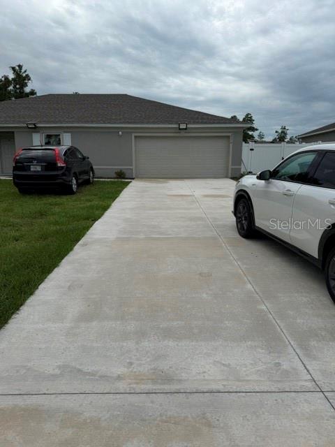A concrete driveway leads to a two-car garage in front of a single-story house — 2776 SW 164TH STREET ROAD, OCALA, FL