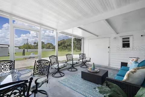 A screened-in patio features a dining set, swivel chairs, and a seating area with cushions — 305 LINDEN DRIVE, ELLENTON, FL