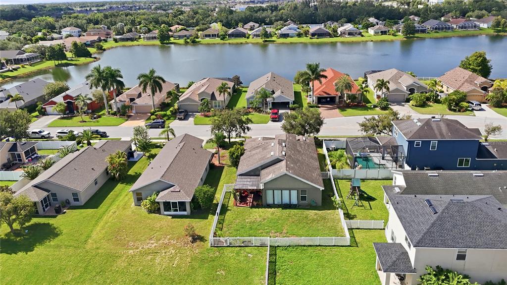 An aerial view shows a suburban neighborhood with single-family homes, green lawns, and a lake — 5310 72ND STREET E, PALMETTO, FL