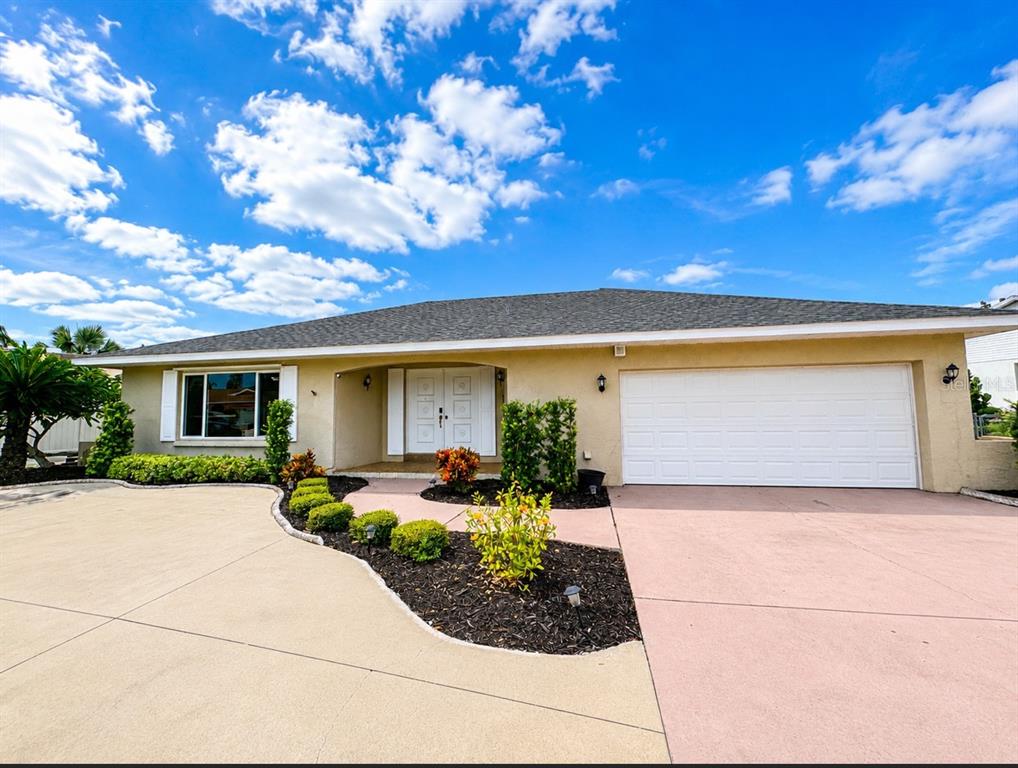 A single-story house with a beige exterior, a two-car garage, and a landscaped front yard — 756 FLAMINGO DRIVE, APOLLO BEACH, FL