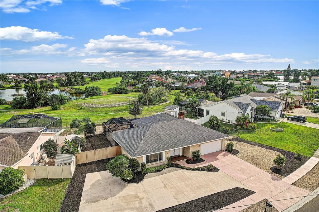 An aerial view shows a single-story house with a gray roof, garage, and backyard pool — 756 FLAMINGO DRIVE, APOLLO BEACH, FL