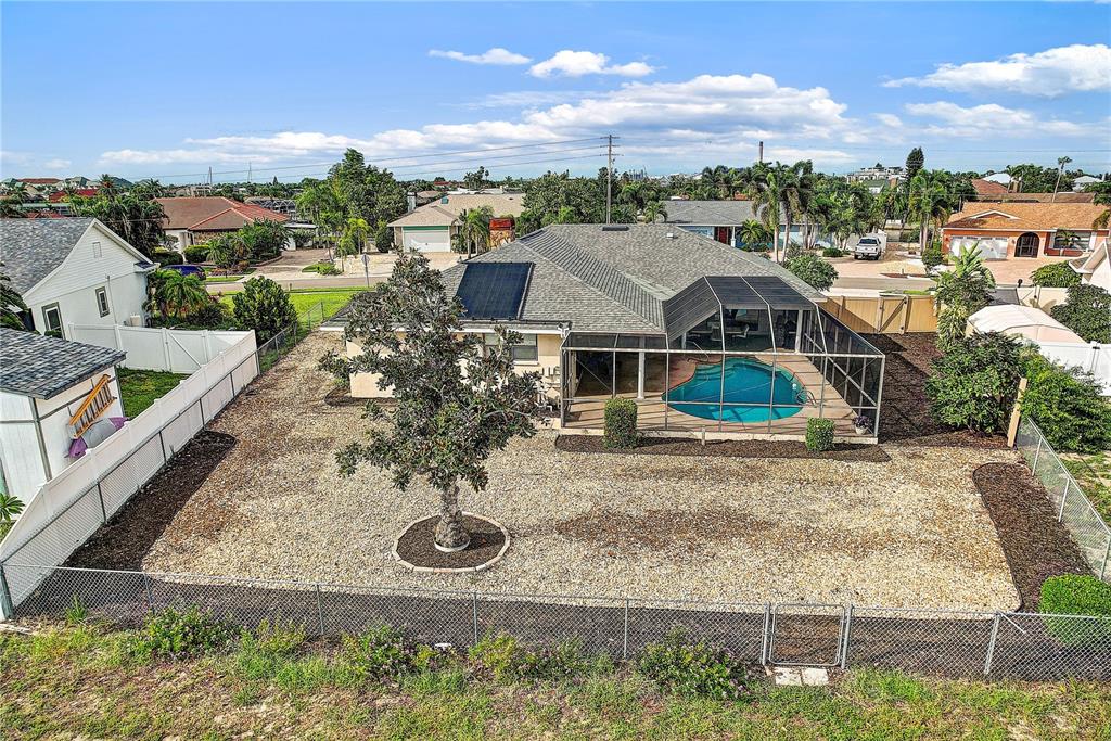 An aerial view of a house with a pool, screened lanai, and gravel backyard — 756 FLAMINGO DRIVE, APOLLO BEACH, FL
