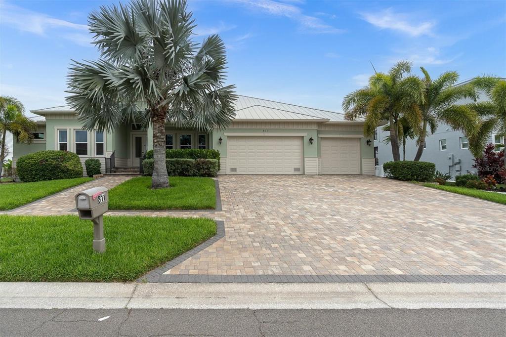 A single-story house with a light green exterior, a paved driveway, and a palm tree — 811 BIRDIE WAY, APOLLO BEACH, FL