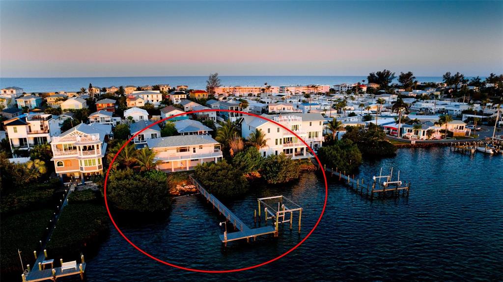 An aerial view of a waterfront house with a private dock and surrounding residential neighborhood — 2512 AVENUE A, BRADENTON BEACH, FL