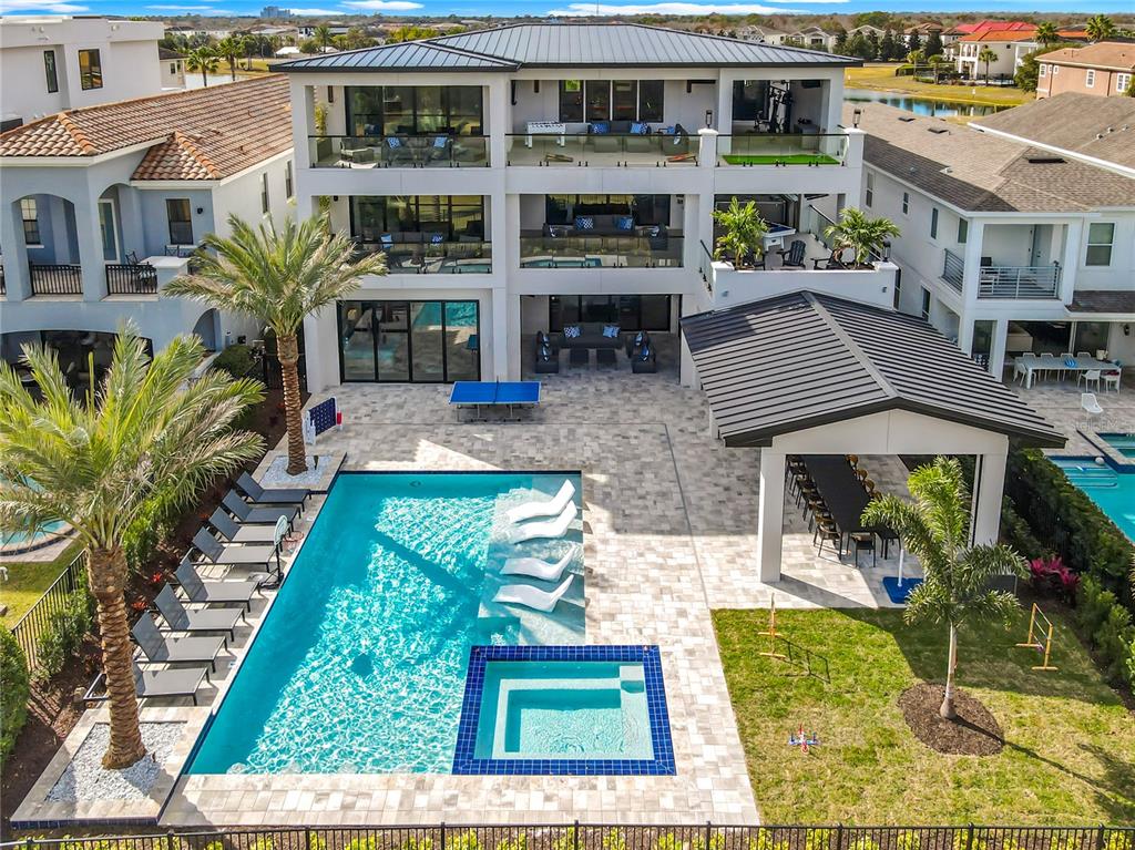 An aerial view of a multi-story house with a pool, spa, and covered patio area — 805 GOLDEN BEAR DRIVE, REUNION, FL