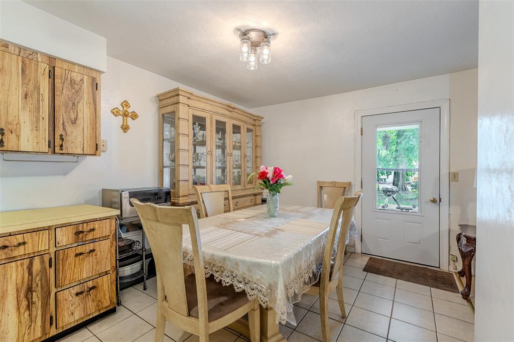 A dining room with a wooden hutch, a table with chairs, and tiled flooring — 17697 NW 222ND STREET, HIGH SPRINGS, FL