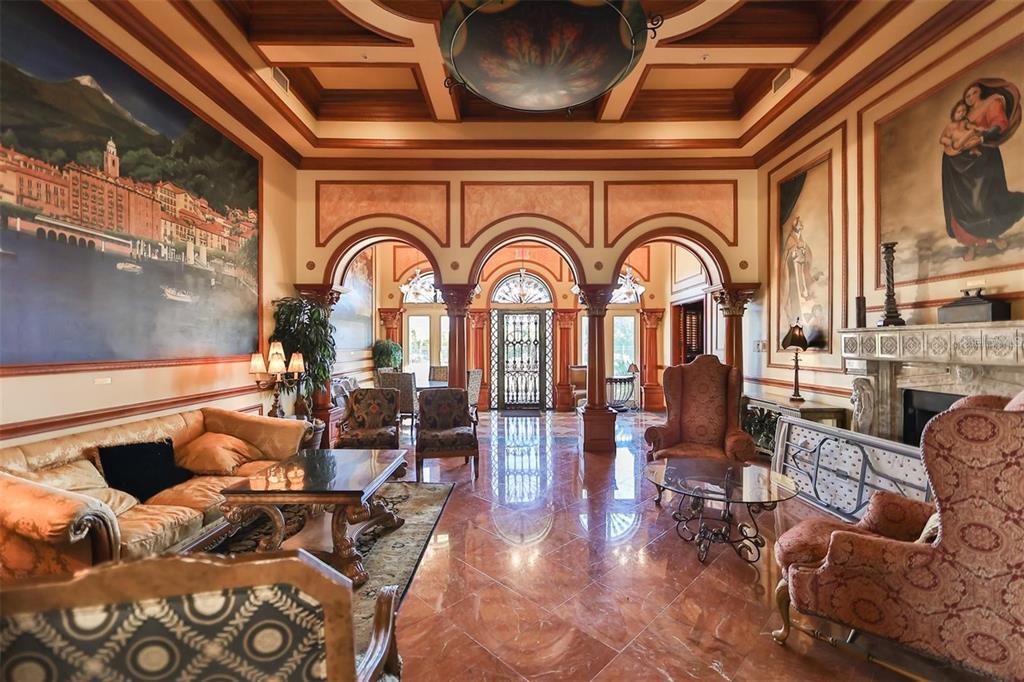 A formal living room features marble floors, arched columns, coffered ceilings, and large wall murals — 2773 VIA CIPRIANI UNIT 1330B, CLEARWATER, FL