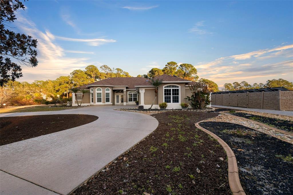 An aerial view shows a house with a pool enclosure on a large, wooded lot — 73 SANCTUARY AVENUE, DEBARY, FL