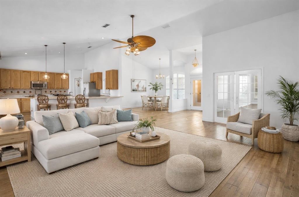 A bright dining area with hardwood floors, a chandelier, and a double-door entryway — 73 SANCTUARY AVENUE, DEBARY, FL