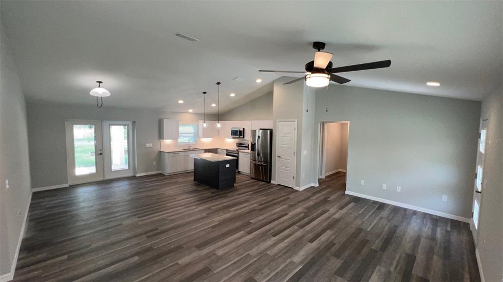 An open-concept kitchen and living area features wood-look flooring, a center island, and recessed lighting — TBD BAY LANE LOOP, OCKLAWAHA, FL