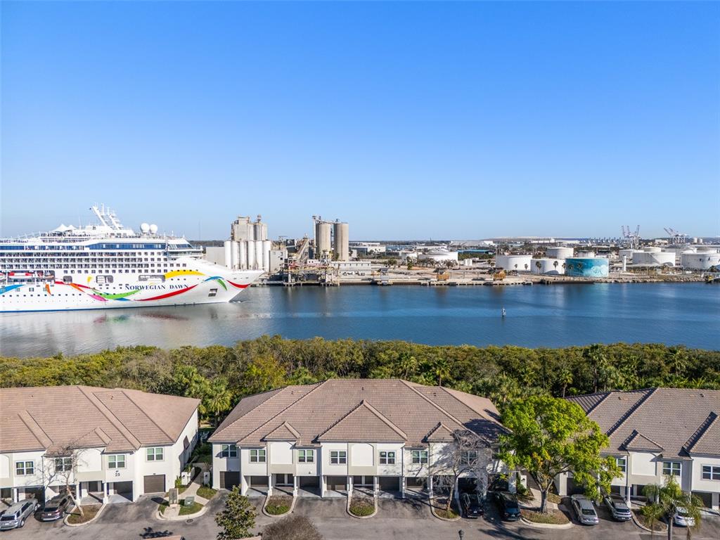 An aerial view shows a multi-unit residential building with a cruise ship in the background — 1037 NORMANDY TRACE ROAD, TAMPA, FL