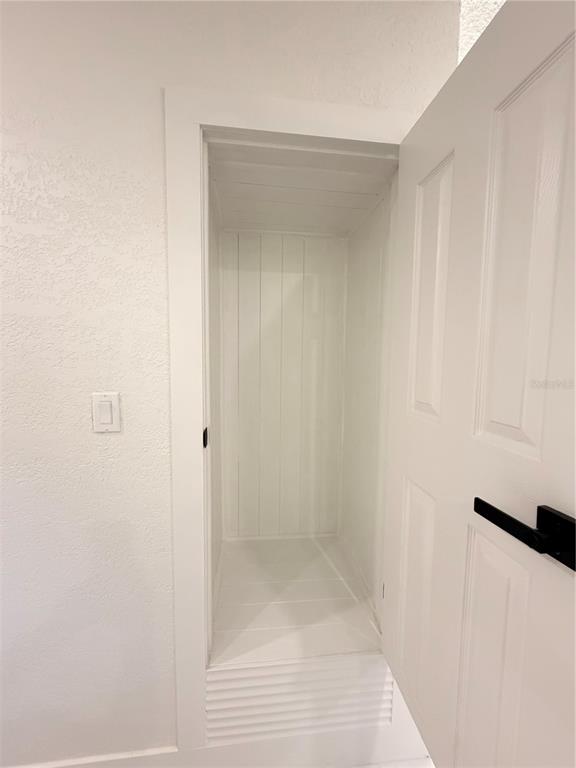 An open-concept kitchen and living area feature white cabinets, a breakfast bar, and tiled floors — 2405 21ST AVE W, BRADENTON, FL
