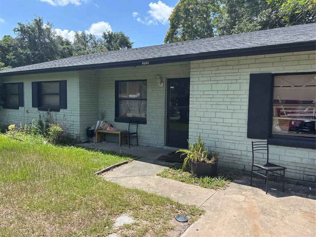 A single-story house with light green brick siding, a dark roof, and black window shutters — 4648 PIEDMONT CT COURT, ORLANDO, FL