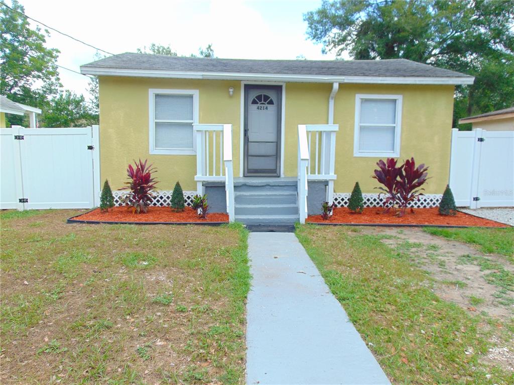 A yellow single-story house with a concrete walkway and a small front porch — 4214 E PALIFOX STREET, TAMPA, FL